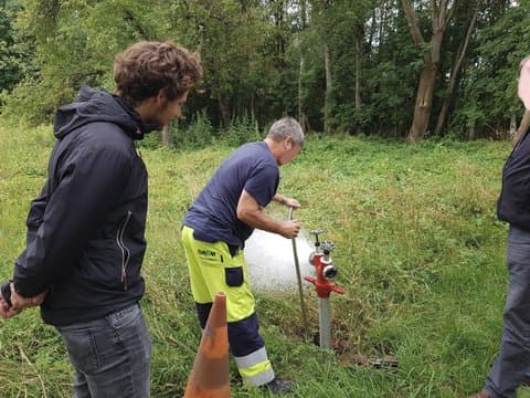 Workers performing actions on a pipe section